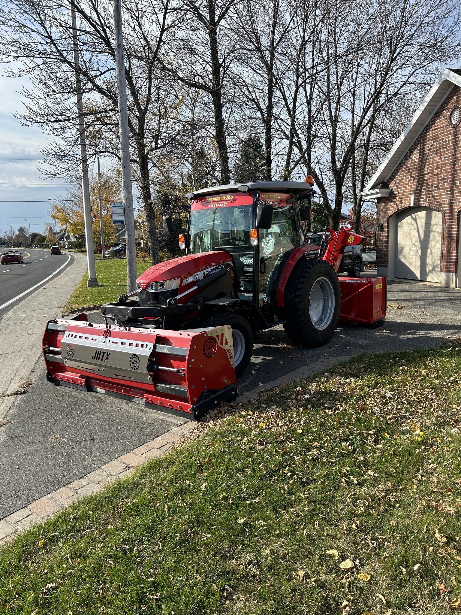 Tracteur Entretien JCG stationné près d'une résidence